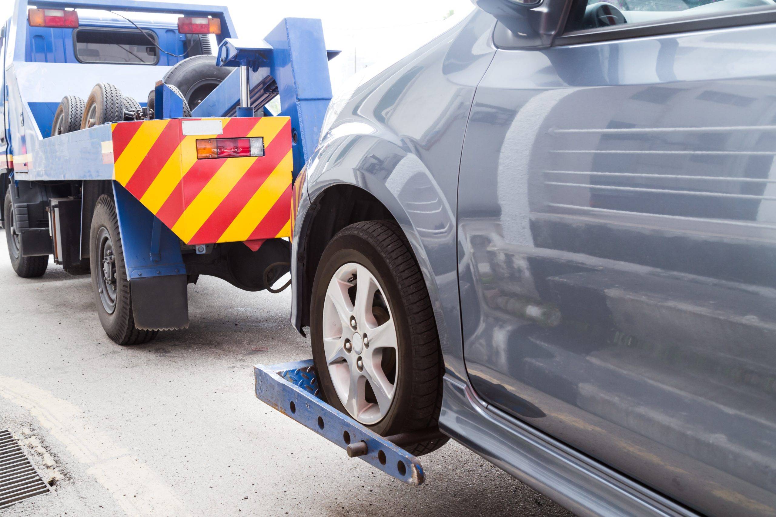 Tow Truck Towing A Broken Down Car On The Street Tow Truck Towing A Broken Down Car On The Street